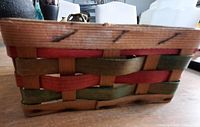 Side view showing woven red, green and natural splints and stitched rim