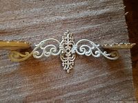 Full view of off-white cast iron double wall sconce on rug background