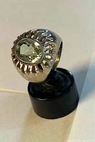 Front view of sterling silver ring on stand showing faceted lemon topaz