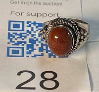 Front view of sterling silver ring with oval goldstone cabochon and rope border