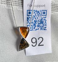 Pendant close-up showing golden and green amber in sterling silver