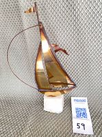 Front view showing brass sails, copper mast, quartz base, size reference tag 59