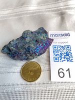 Top view of iridescent bornite next to Canadian dollar coin