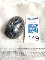 Egg-shaped stone beside size reference card