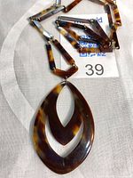 Necklace with pendant, close up on links and tag