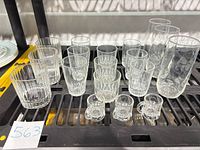 Full group of assorted clear pressed glassware on rack