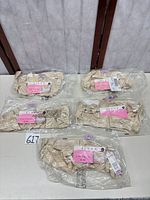 Five sealed beige bras laid out on table