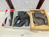 Three shoe boxes open showing Coach loafer pair and two Lucky Brand ankle boot pairs