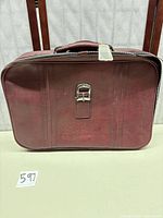 Front of burgundy hard-sided Flying Time suitcase