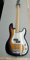 Full body view of Lyon sunburst bass showing pickguard, bridge, pickup