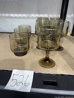 Group of 10 smoky amber glasses showing 6 stemmed goblets and 4 tumblers