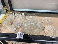All 10 pressed glass pieces arranged on shelf