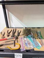 Full lot showing pliers, hammer, auger bits, packaged drill bits