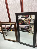 Brown and black framed mirrors side by side