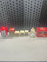 Front view of all seven items aligned showing each box and loose angel