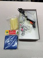 Overview of lot showing glue gun, glue sticks, storage box and accessories