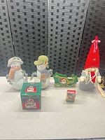 All items grouped: two snowmen, wooden sleigh, boxed waterglobe, small boxed item, plush gnome