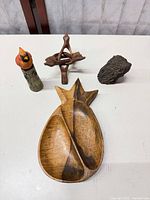 All four items grouped: wood pineapple dish, cardinal figurine, tripod stand, fossil wood