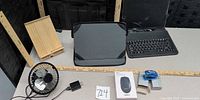 All items laid out: fan, charger, bamboo stand, lap desk, folio keyboard, mouse box, stapler, staples