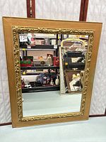 Full view of gilt framed mirror standing upright