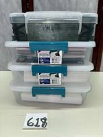 Front view of four stacked plastic storage boxes showing colors, latches, and contents