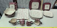 all 15 pieces displayed: serving tray, mugs, bowls, plates, maker’s marks visible