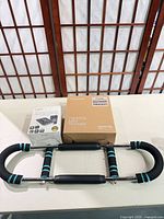 Twister arm trainer assembled with both boxed items on table