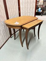Both nesting tables together, larger oval table with smaller rectangular table partially underneath