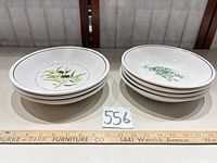 Two stacks of bowls showing olive and thyme patterns, ruler for scale