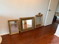 All three mirrors leaning against wall showing sizes and frames