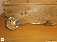 Overall view of silver-plated ladle on wood surface