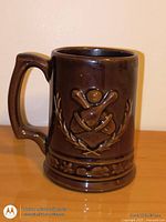 Front view of brown Beauceware pottery mug showing baseball relief and handle