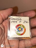Front of plastic holder showing label and colorized Georgia quarter