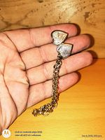 Bracelet in hand showing double-sided heart locket and chain detail