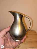 Front view of pewter decanter jug showing spout, handle, and brushed finish