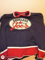 Front view navy Shoeless Joe's jersey with logo visible