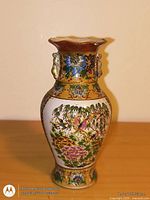 Front view of hand-painted ceramic vase showing floral design and gilt accents