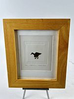 Full view of framed etching in light wood frame