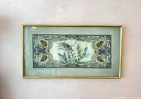 Full view of framed silk panel on wall