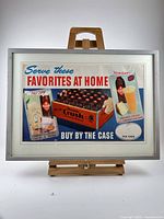 Full view of framed Orange Crush poster on easel