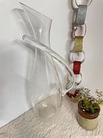 Full view of clear glass decanter showing curved handle and angled rim