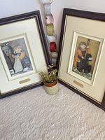 Both framed Steve Lamb prints standing on carpet