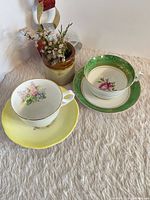 Two bone china tea cup and saucer sets displayed