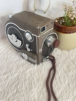 Front and side view showing lens assembly, controls and strap