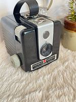 Front view showing Kodak Brownie Hawkeye Flash Model camera body, lens, viewfinder window, nameplate, and side winding knob