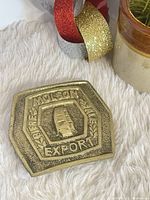 Front view of brass Molson Export belt buckle