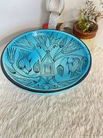 Top view showing entire bowl, fish and flower motifs, blue glaze