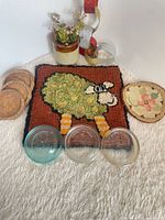 Group shot of all coasters: wood stack, glass trio, wool hooked sheep piece, round felt floral
