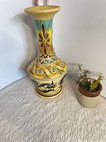 Full view of vase next to small planter for scale