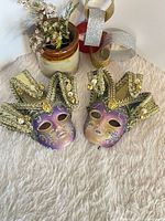 Two mini jester masks on surface